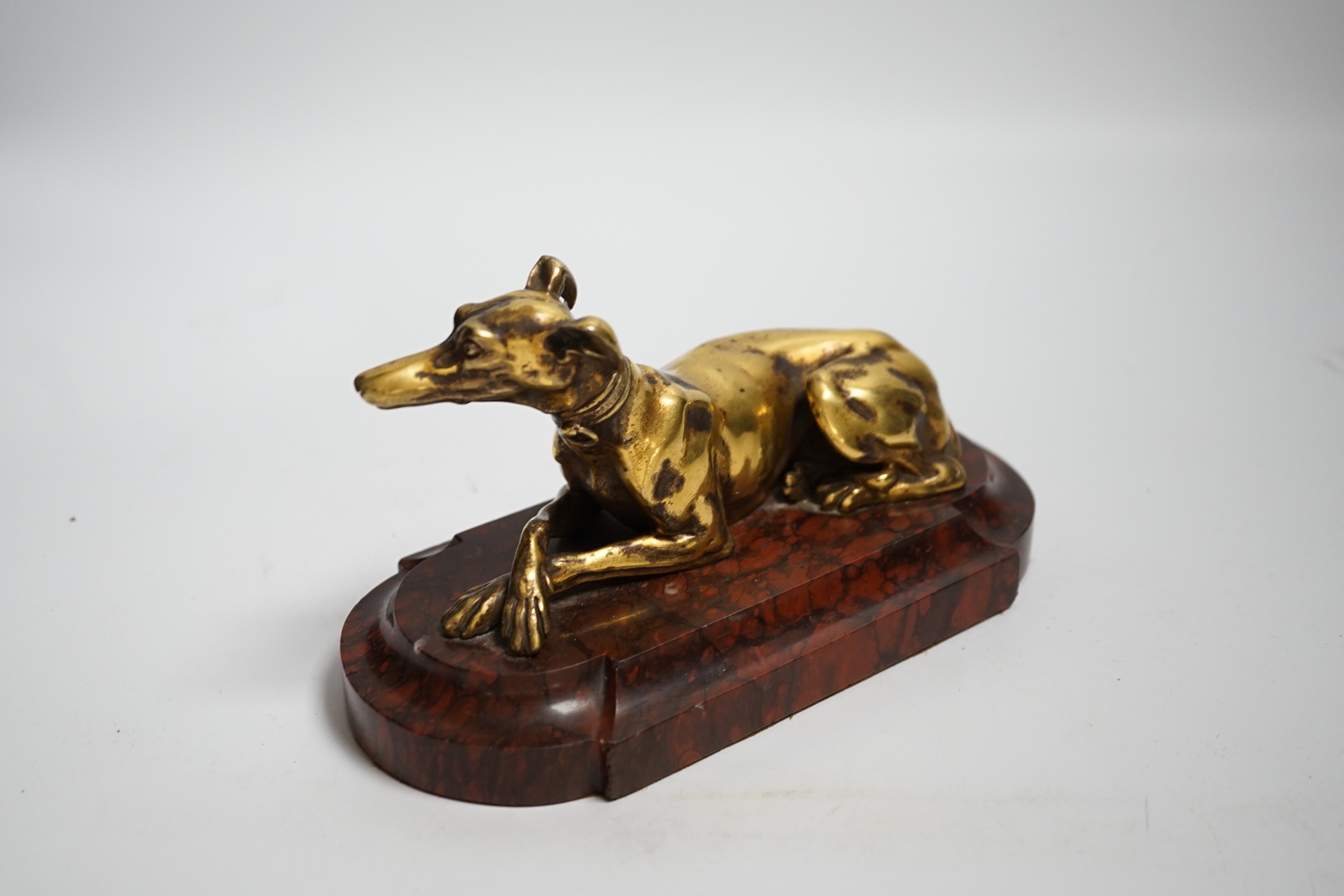 A 19th century French gilt bronze of model of a recumbent greyhound on a rouge marble plinth, 19cm wide